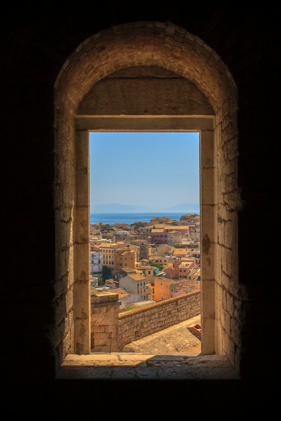  view of concrete buildings from window during daytime door frame