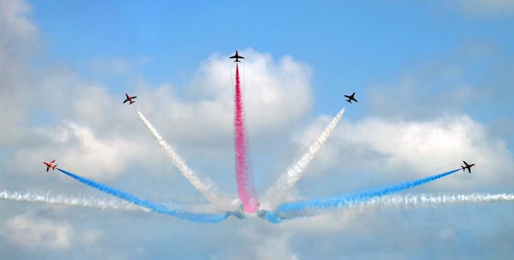 Espectáculo del cielo de cinco aviones de colores variados durante el día