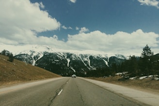 A scenic mountain road with a rental car ready for a road trip.