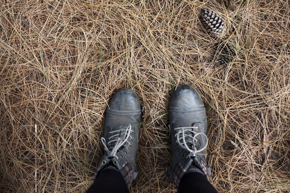 person wearing pair of black work boots in nature