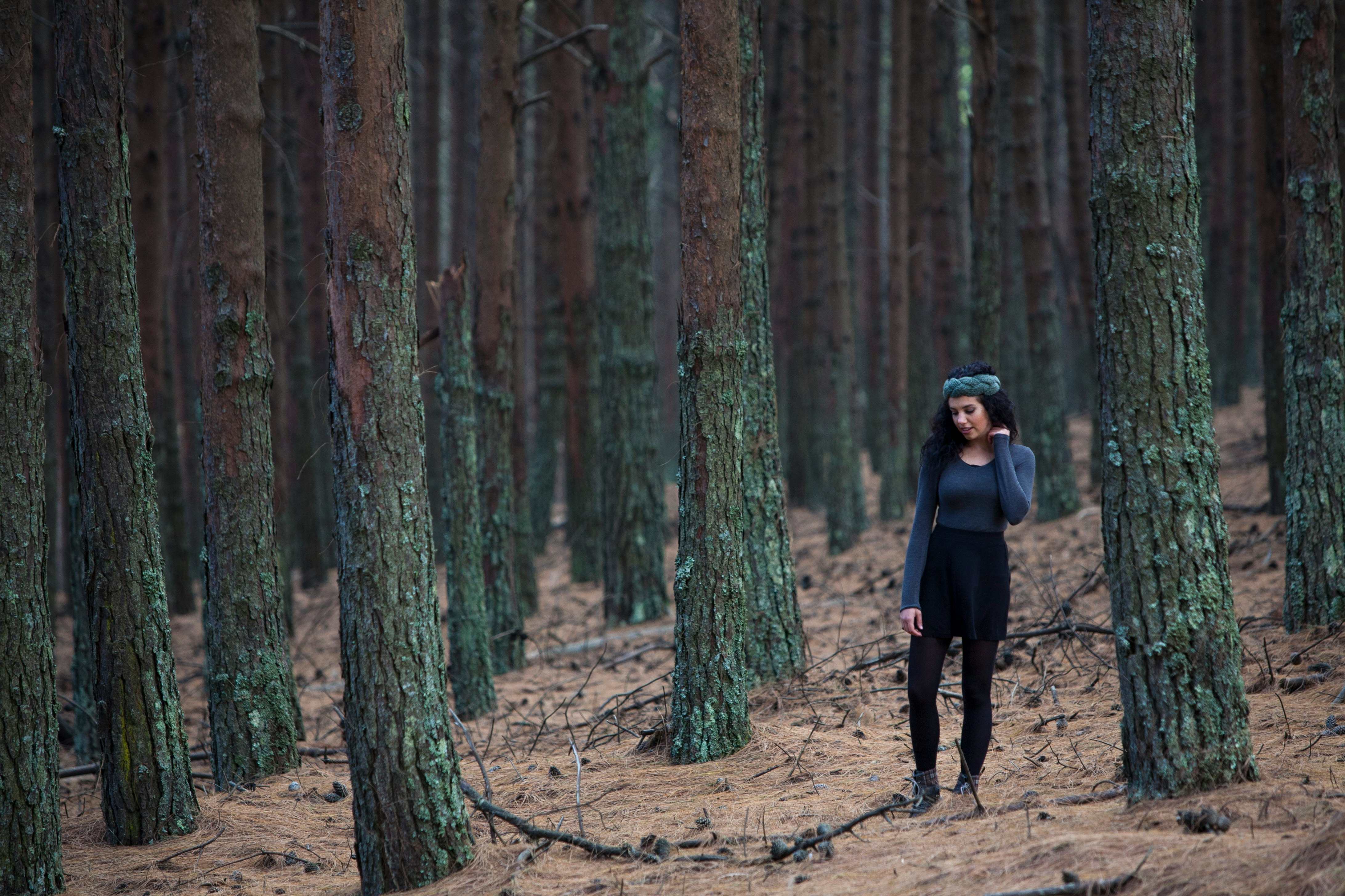 woman standing between trees during daytime