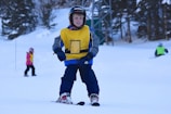 Children participating in a skiing lesson with a coach.