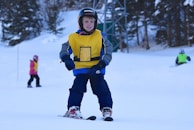 Superbaby category kids learning to ski with their instructor in a sunny winter day.