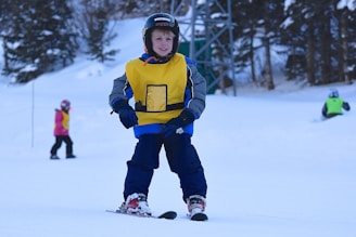 Young children in colorful ski gear learning on gentle slopes in Pinzolo.