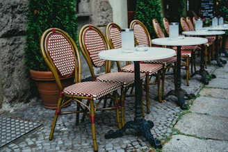 Sturdy fiberglass and aluminum tables set up in a stylish outdoor café setting
