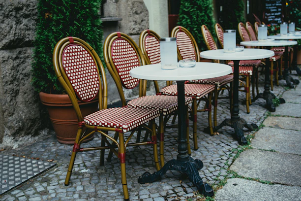 Sturdy fiberglass and aluminum tables set up in a stylish outdoor café setting