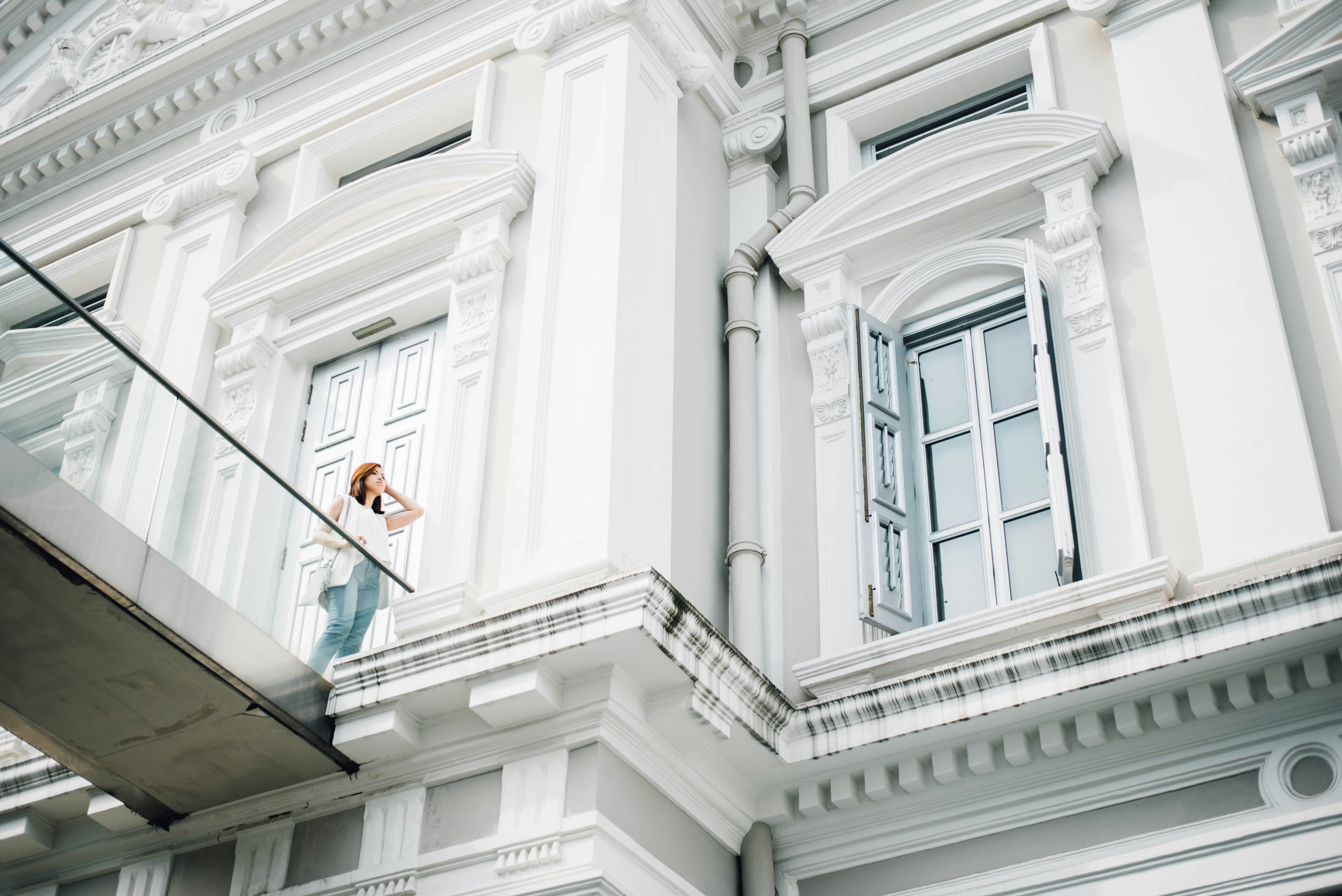 Woman Standing On White Concrete Building Terrace Photo Free