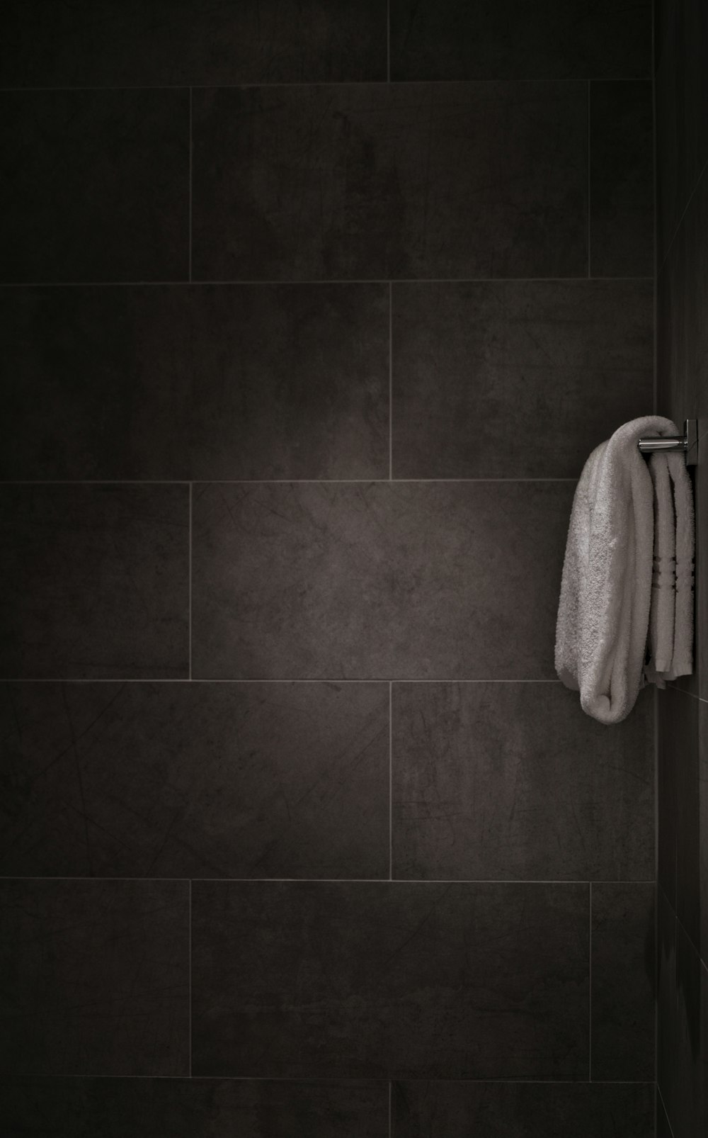 white bath towel hanged on bar