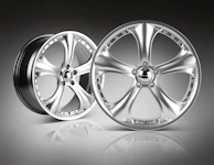 Polished alloy wheels shining brilliantly against a dark, moody background.