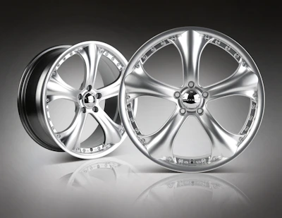 High-performance alloy wheels shining under showroom lights with graphite and electric blue accents