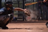 Close-up of a baseball flying toward the catcher inside the cage during a practice session.