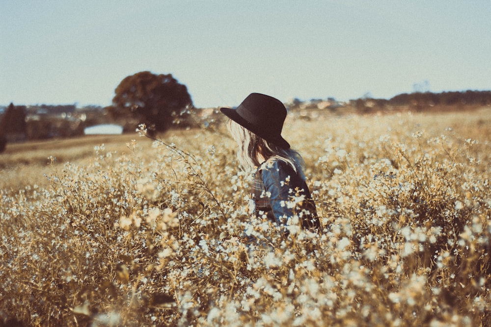 a woman standing in a field of tall grass