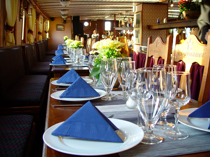 A cozy setup of a lunch service table with plates, cutlery, and glasses ready for guests.