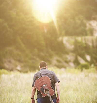 man walking on green grass field during daytime