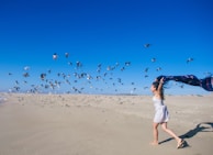 A joyful woman running on a beach.