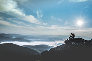 man sitting on rock during daytime