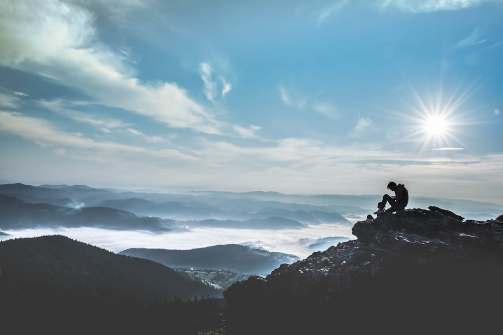 Mann, der tagsüber auf einem Felsen sitzt