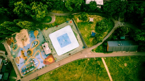 A panoramic view of a spacious playground featuring both wooden and plastic play structures.