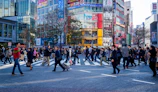 A bustling city street with diverse professionals crossing at a busy intersection.