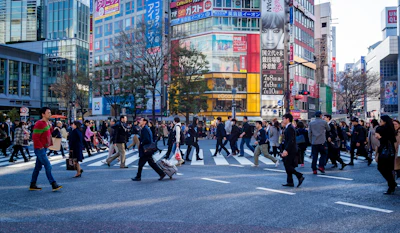 A bustling city street with diverse professionals crossing at a busy intersection.
