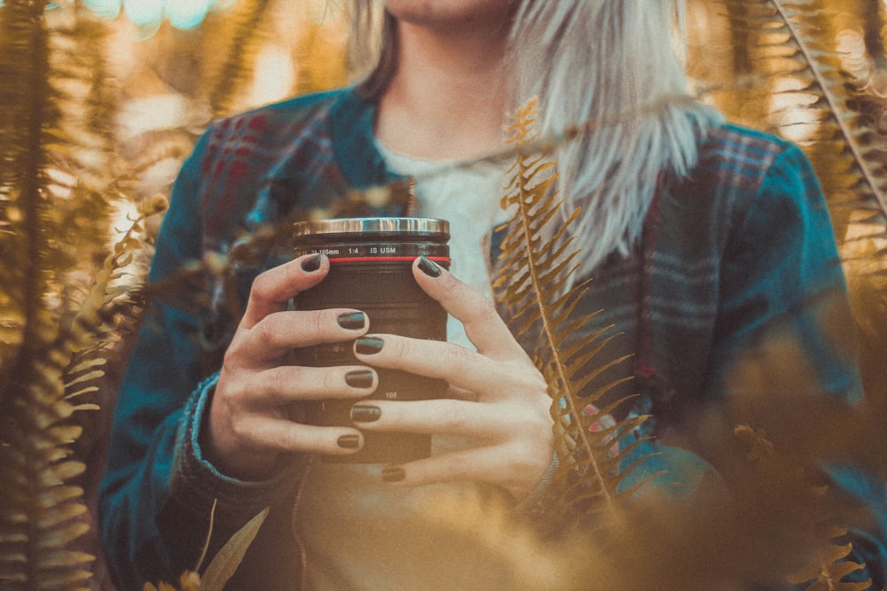 woman holding black and gray mug