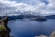 man standing on lake cliff near mountain alps