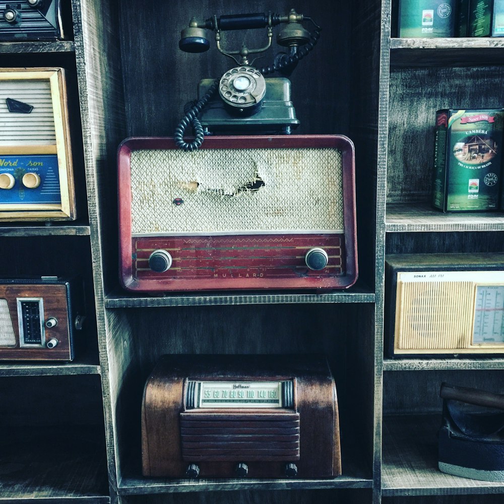 black rotary telephone on red transistor radio