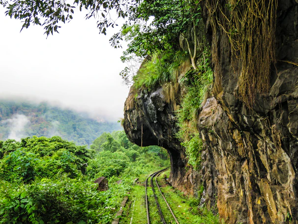 A scenic mountain railway track winding through misty hills.