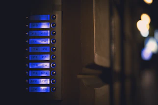 A sleek, modern smart home control panel glowing softly in a dimly lit room.