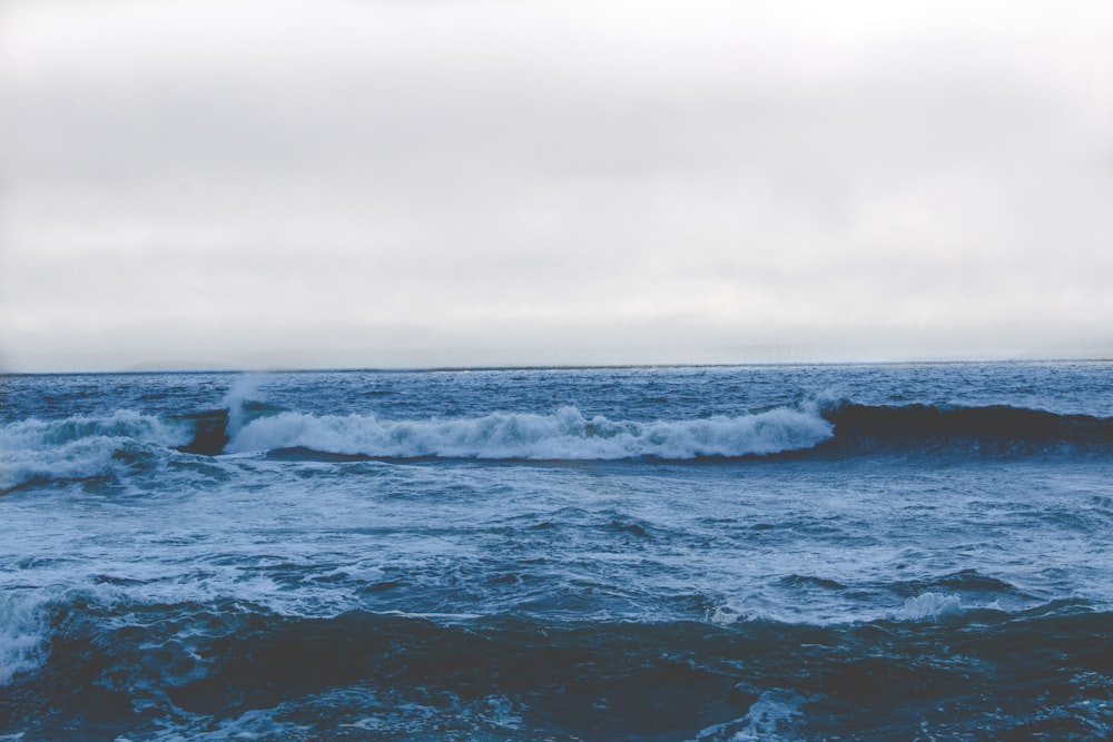 blue ocean water waves under cloudy sky during daytime