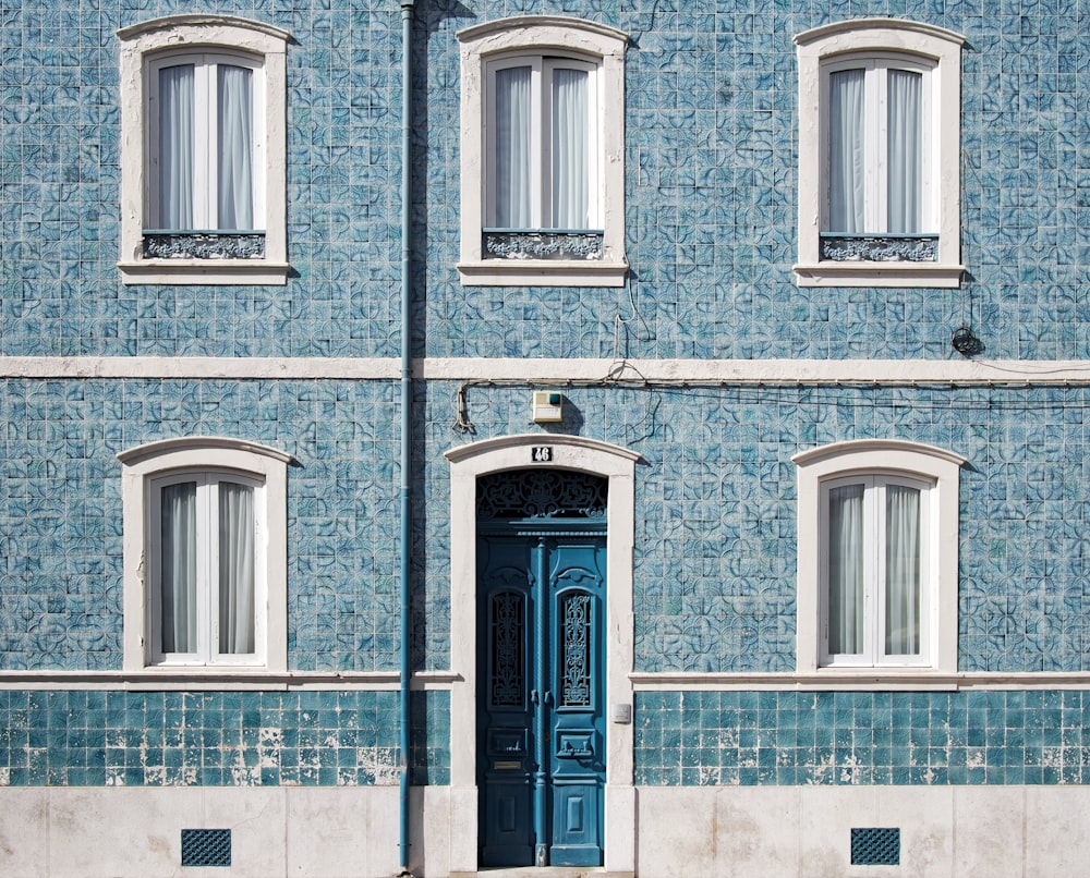 blue and white concrete house with five windows