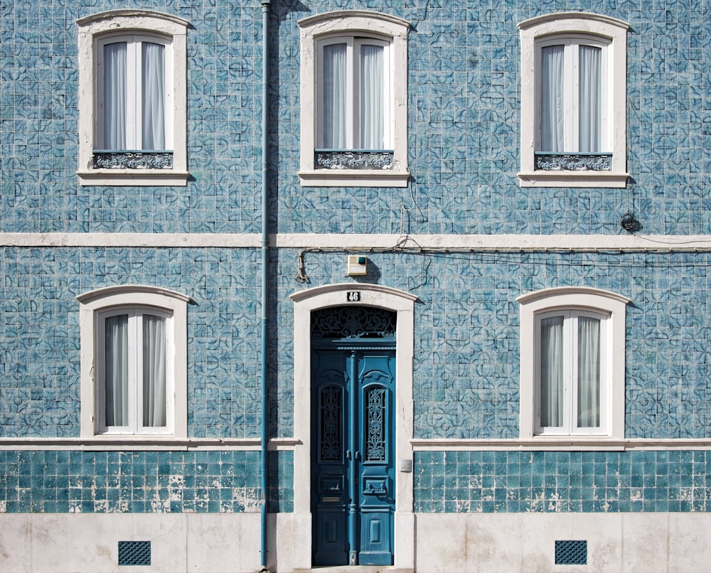 Blau-weißes Betonhaus mit fünf Fenstern