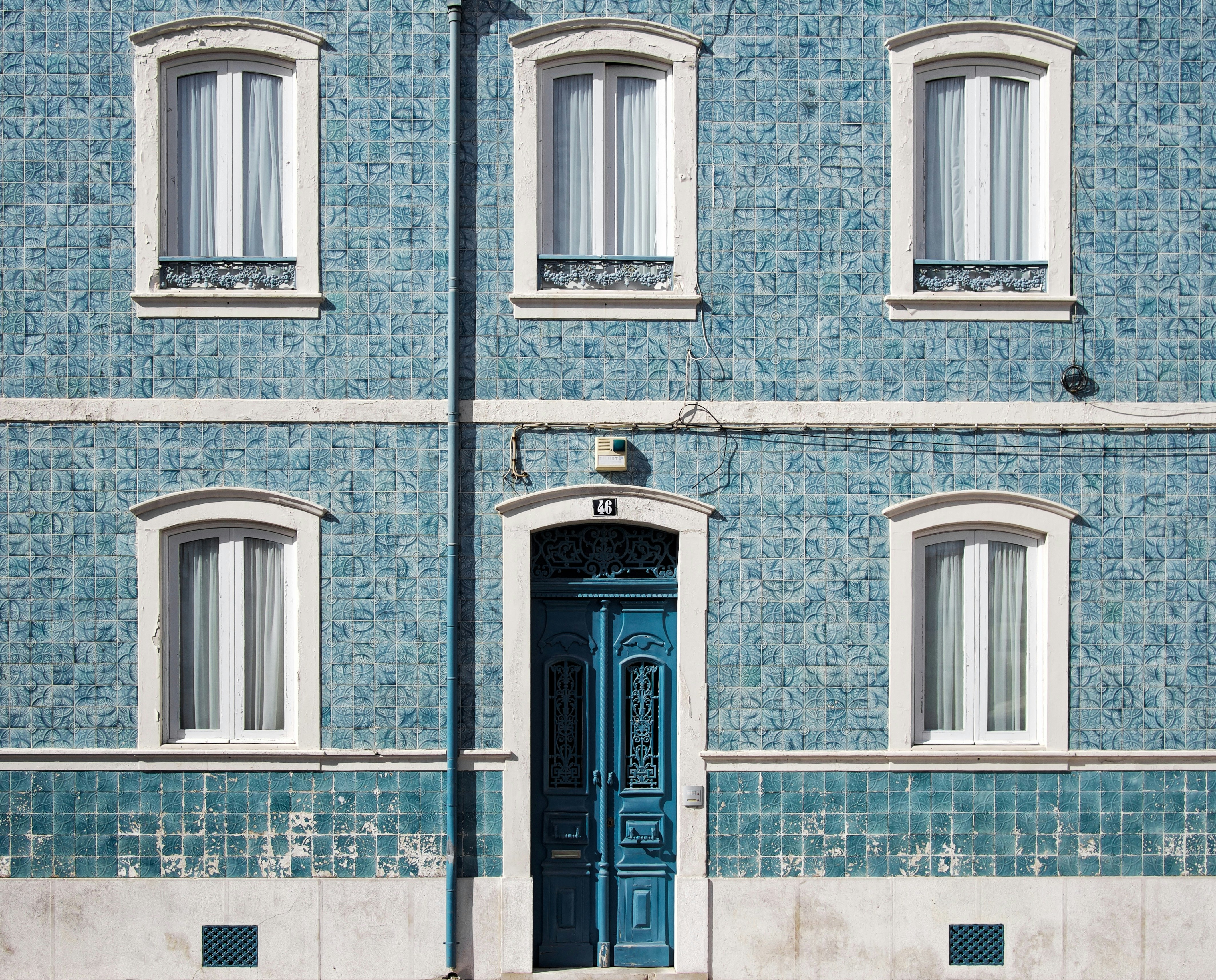 blue and white concrete house with five windows