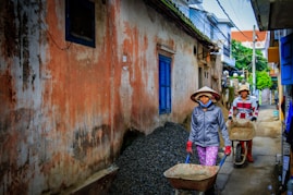 two women walking beside orange house