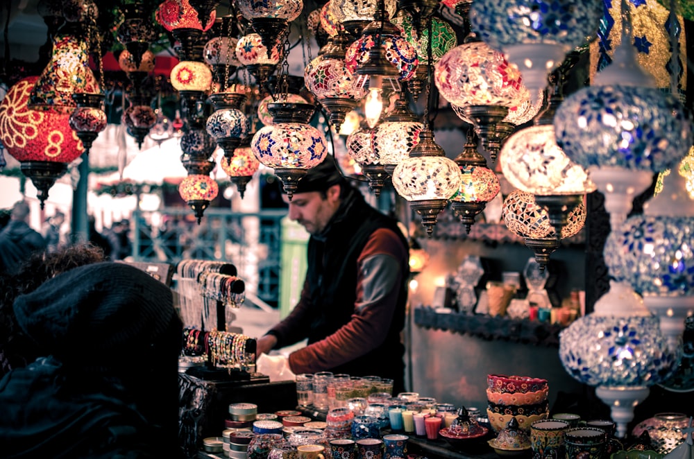 Colorful lanterns hanging above a street market stall with various decorative items