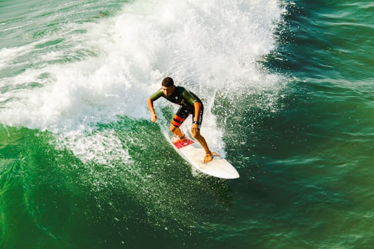 man on surfboard surfing against waves in Imperial Beach United States