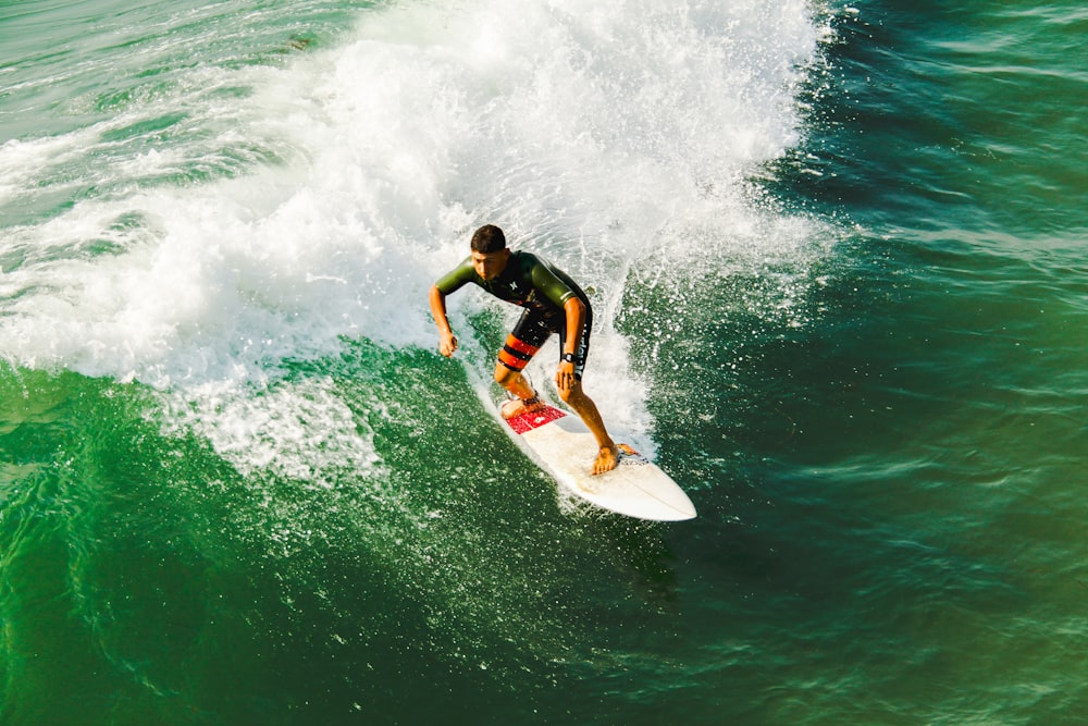 homem na prancha surfando contra as ondas