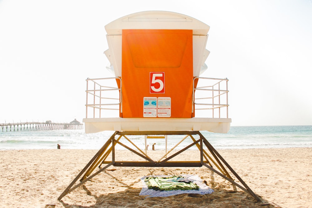 orange and white shed in front of shore