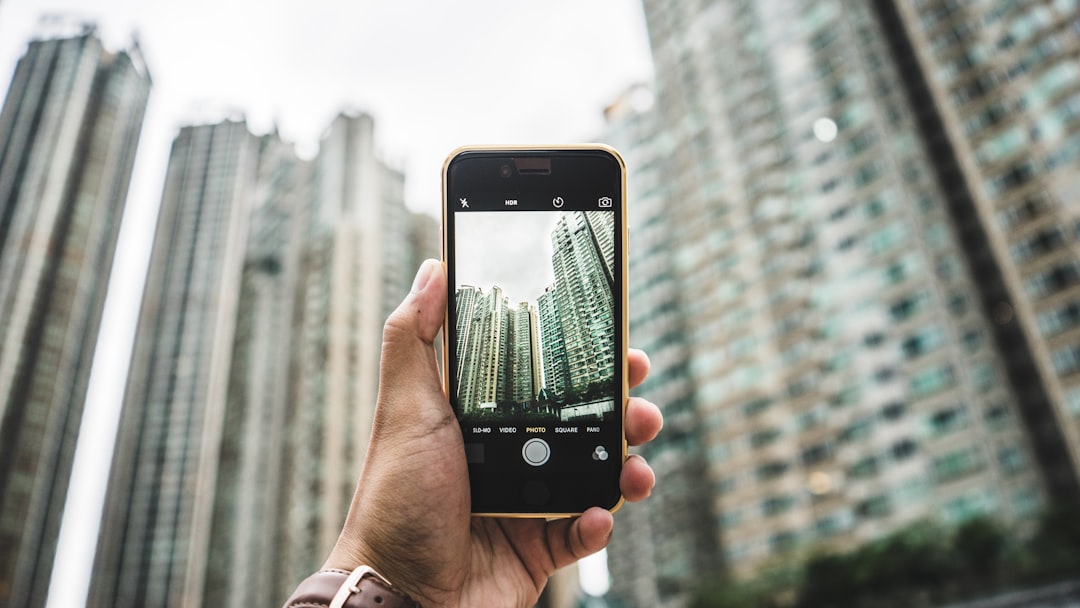 person using smartphone taking picture of building, Photographing skyscrapers
