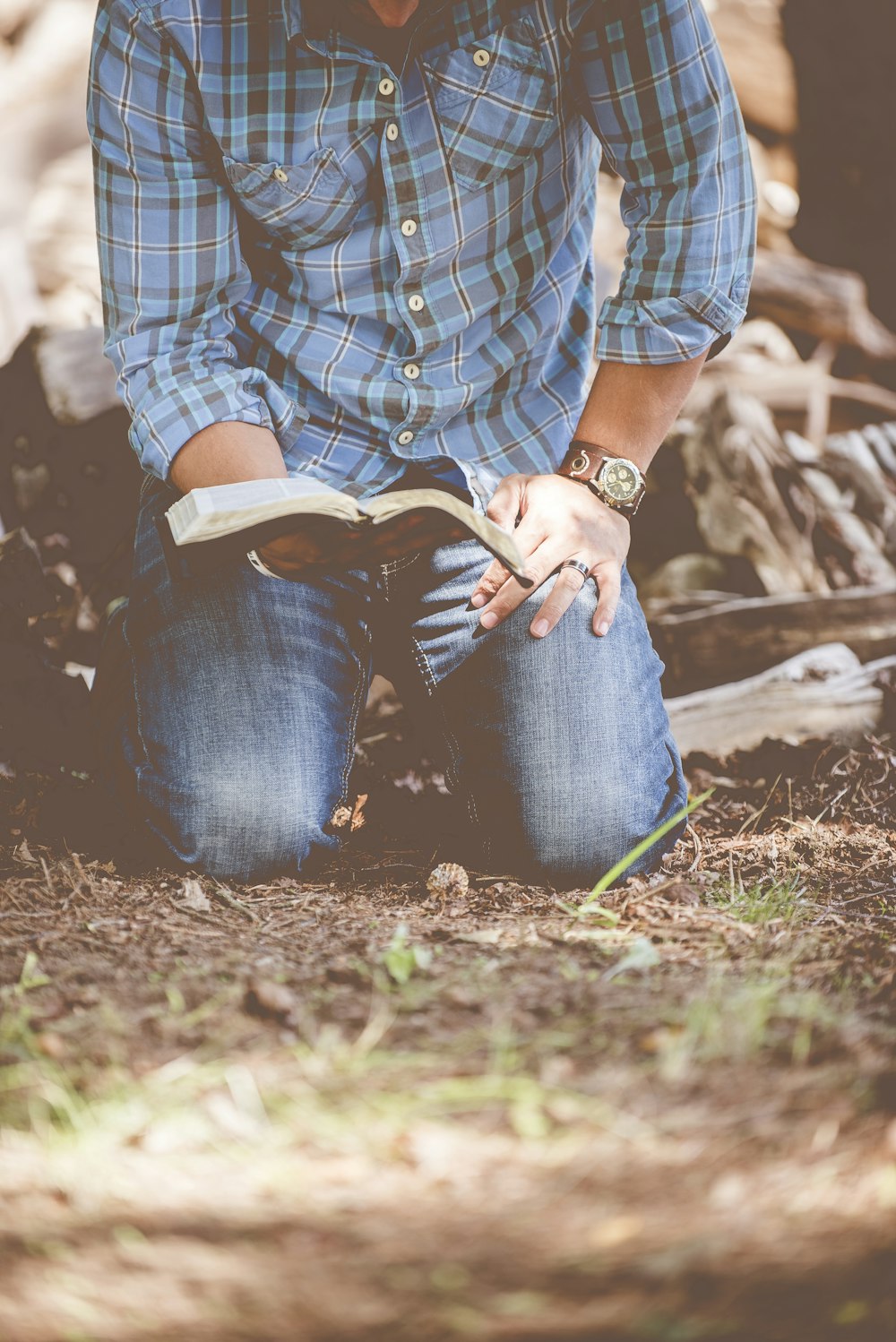 Person, die ein Buch liest, während sie kniet