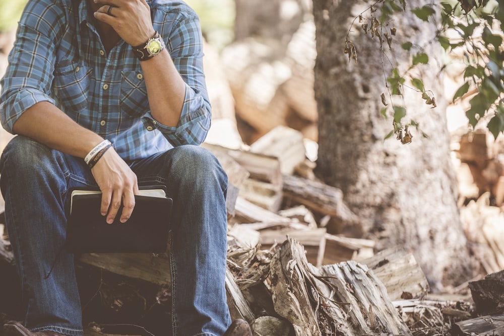 man wearing blue plaid dress shirt and blue jeans