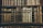 A collection of vintage, leather-bound books arranged neatly on wooden shelves. The spines of the books display intricate gold embossing and titles, showcasing a sense of antiquity and elegance.