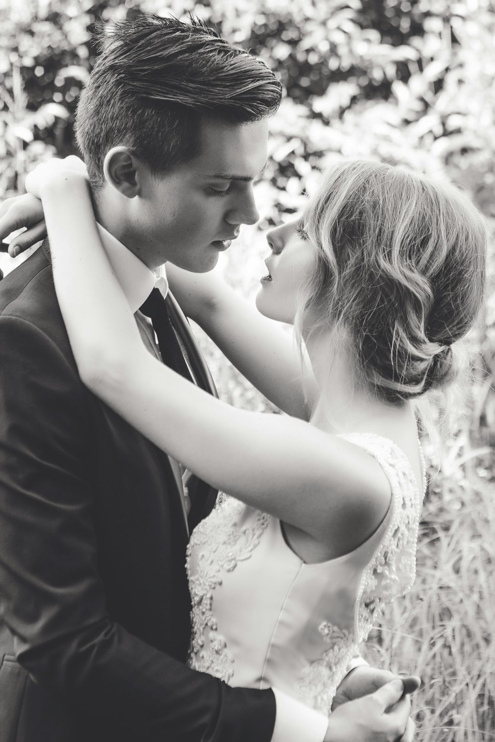 A bride and groom hugging and about to kiss.