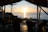Guests enjoying a serene sunset view from a wooden deck overlooking the calm sea.