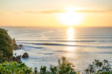 Sunset over the lush Pacific coastline, highlighting the natural beauty surrounding the cultural experiences.