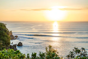 Sunset over the lush Pacific coastline, highlighting the natural beauty surrounding the cultural experiences.