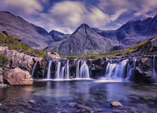 waterfalls under cloudy sky