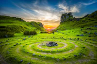 Sunset over a green spiral hill