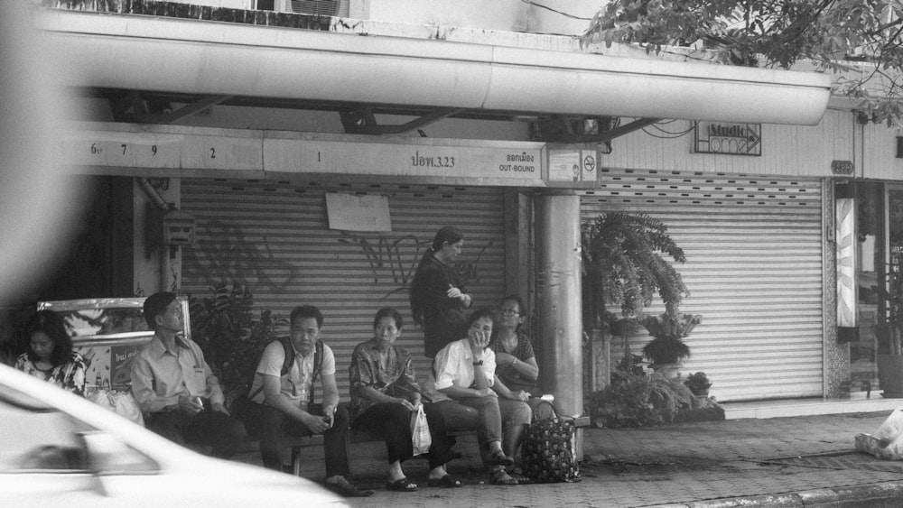 a group of people sitting outside of a store