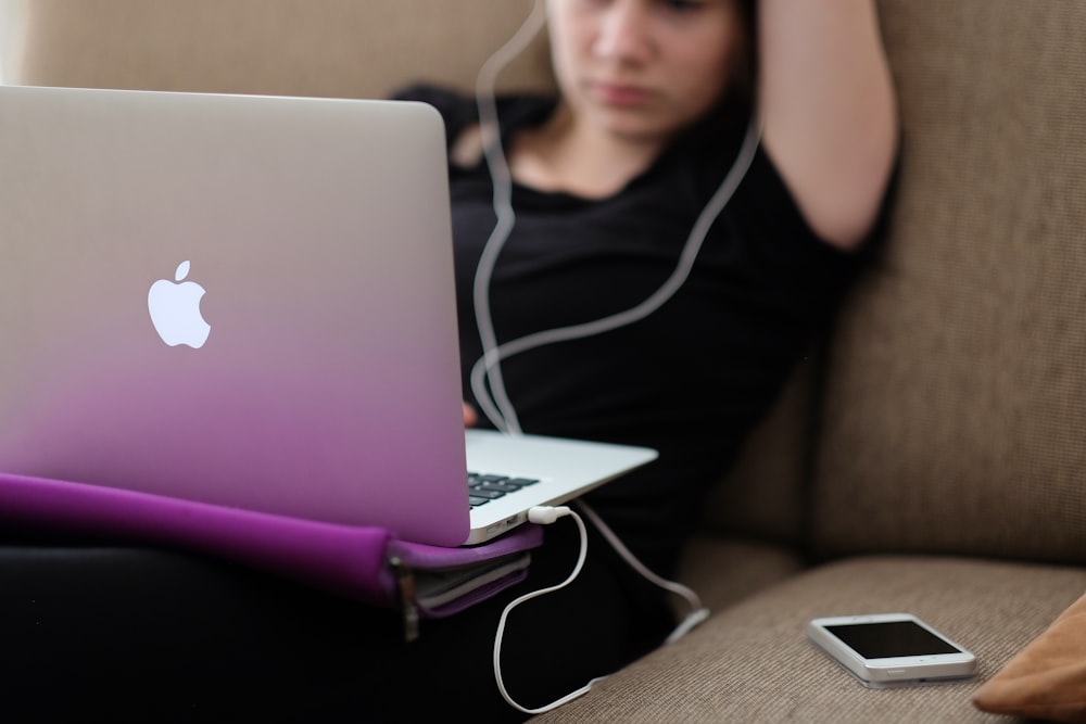 MacBook Air와 함께 소파에 앉아있는 여자